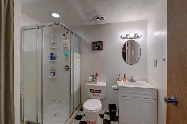 bathroom featuring vanity, toilet, a shower with door, and a textured ceiling