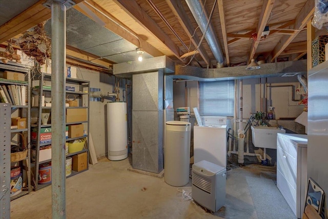 basement featuring sink, gas water heater, and washing machine and dryer