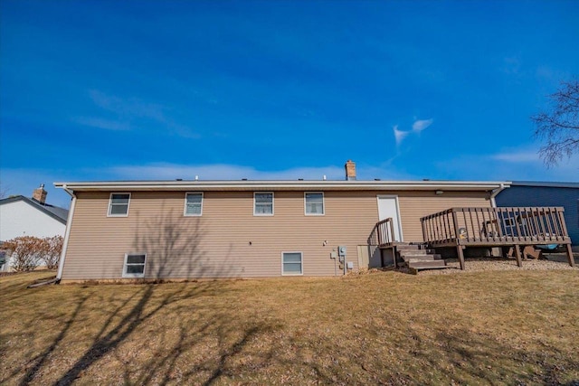 back of property with a deck and a lawn