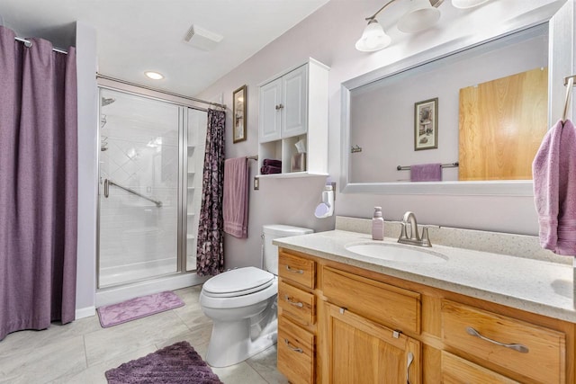 bathroom with vanity, tile patterned floors, toilet, and walk in shower