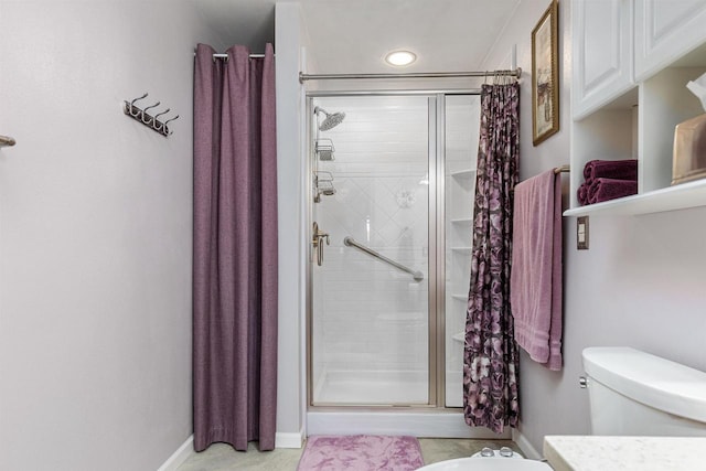 bathroom featuring toilet and a shower with door