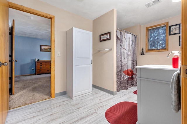 bathroom with wood-type flooring, curtained shower, and vanity