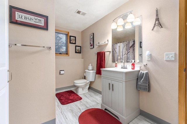 bathroom featuring vanity, wood-type flooring, a shower with shower curtain, and toilet