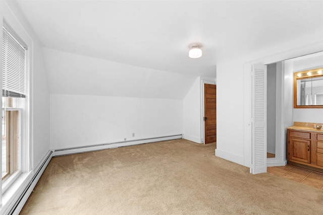 bonus room with lofted ceiling, a baseboard heating unit, light colored carpet, and sink