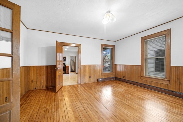 unfurnished room featuring crown molding and light hardwood / wood-style flooring