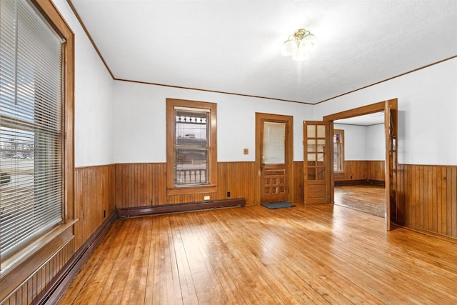 unfurnished room with crown molding, light hardwood / wood-style flooring, and baseboard heating