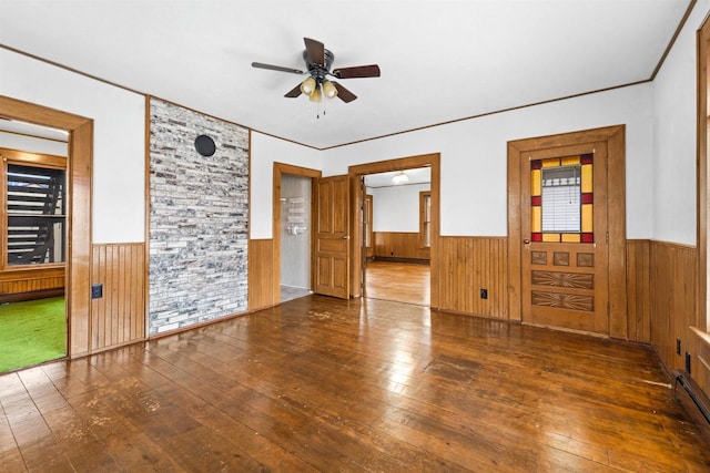 empty room featuring ceiling fan, ornamental molding, dark hardwood / wood-style flooring, and baseboard heating