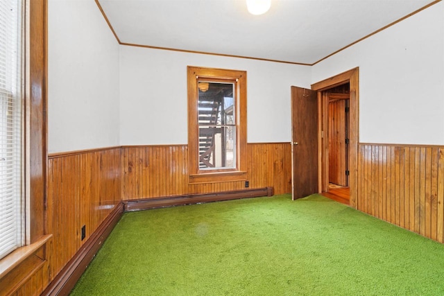 carpeted empty room featuring a baseboard heating unit and ornamental molding