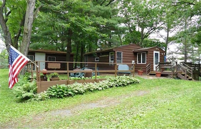 back of property with a wooden deck and a yard