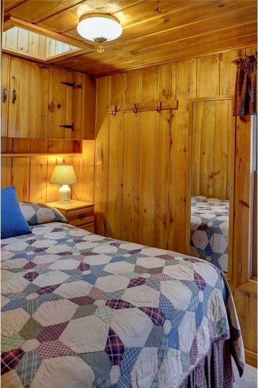 bedroom featuring wood ceiling and wood walls