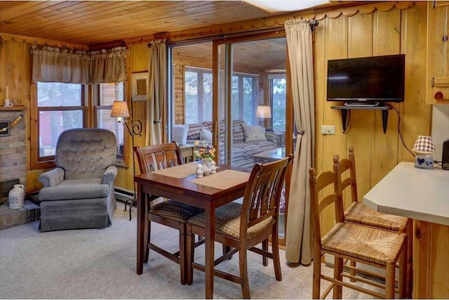 carpeted dining space with wooden ceiling, baseboard heating, and wood walls