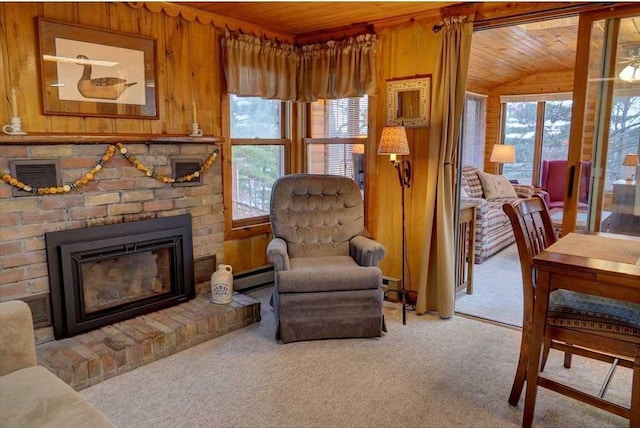 interior space featuring wood walls, wood ceiling, vaulted ceiling, a brick fireplace, and light colored carpet