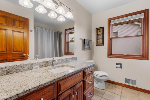 bathroom with tile patterned flooring, vanity, and toilet