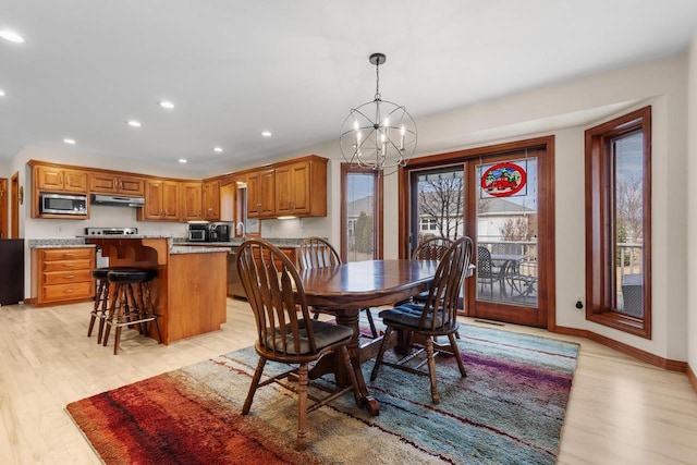 dining area with an inviting chandelier and light hardwood / wood-style flooring