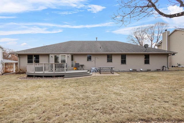 rear view of house with a wooden deck and a yard