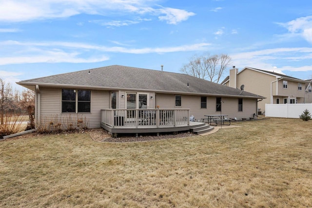 rear view of property featuring a wooden deck and a yard