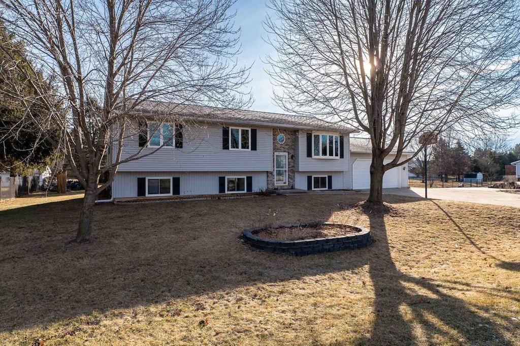 raised ranch with a garage and a front yard