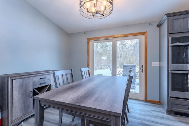 dining area with a notable chandelier and light wood-type flooring