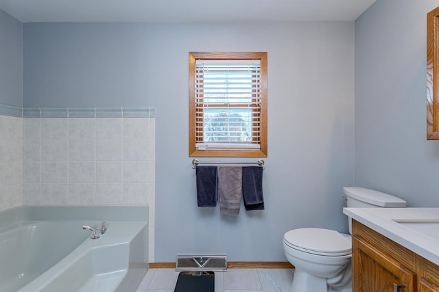 bathroom featuring vanity, a washtub, tile patterned floors, and toilet