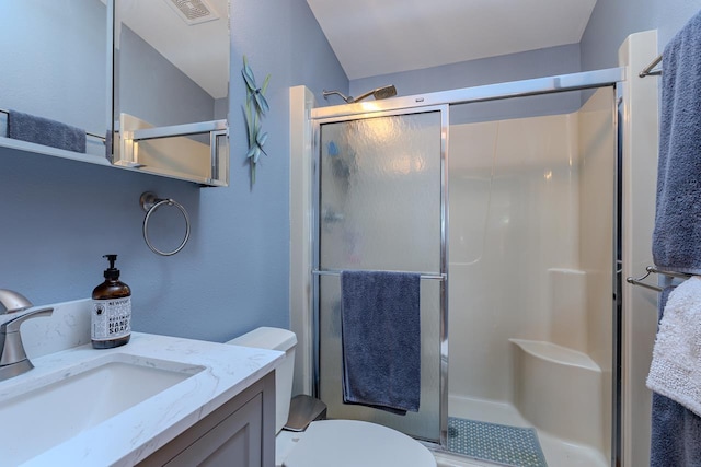 bathroom featuring vanity, toilet, and walk in shower