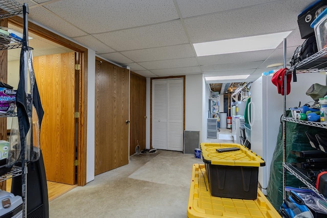 basement with a paneled ceiling and wood walls