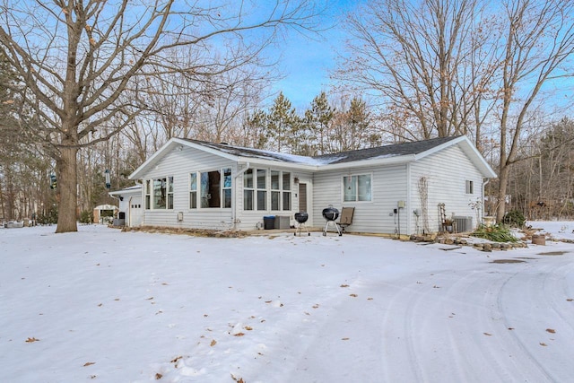 snow covered back of property featuring cooling unit