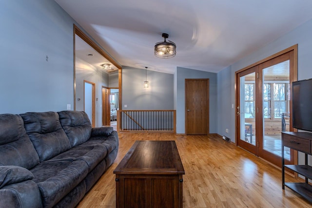 living room featuring lofted ceiling and light wood-type flooring