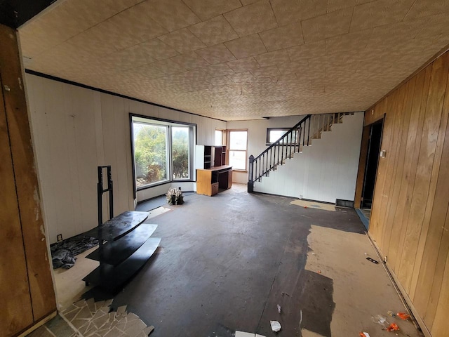 miscellaneous room featuring wooden walls and concrete flooring