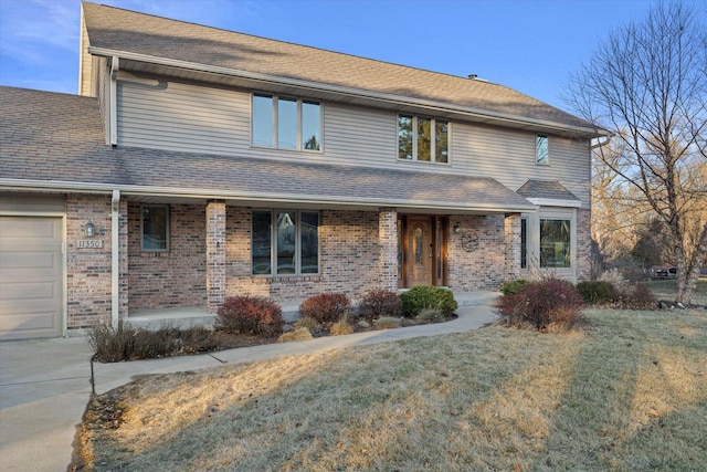 front of property with a garage, a front yard, and a porch