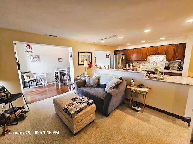 carpeted living room with sink