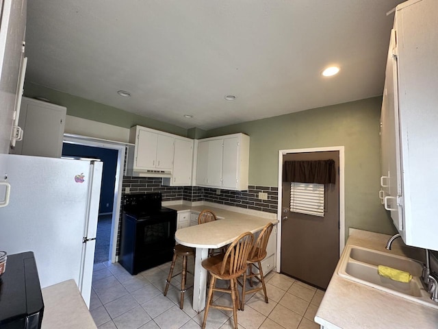 kitchen with sink, white cabinets, white fridge, light tile patterned floors, and electric range