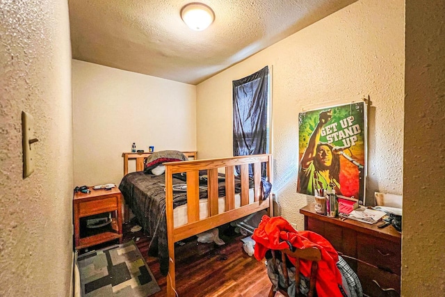 bedroom featuring hardwood / wood-style floors and a textured ceiling