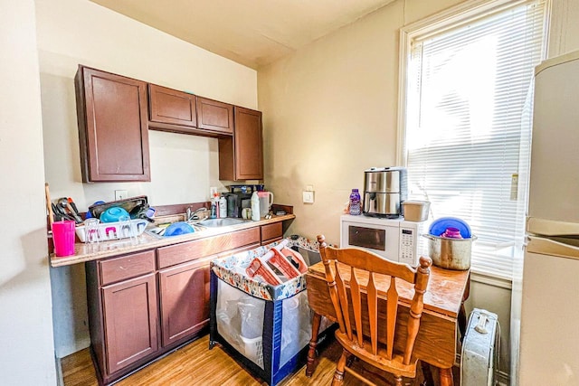 kitchen featuring sink, white appliances, and light hardwood / wood-style flooring