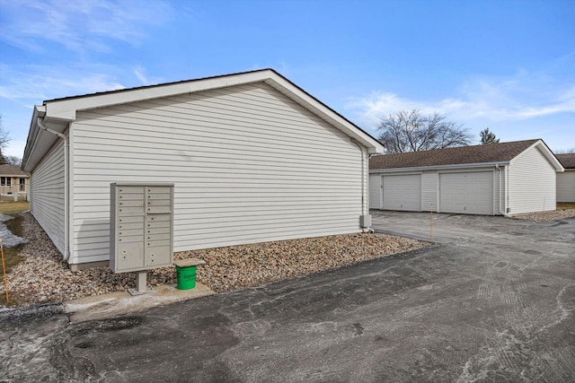 view of side of property featuring a garage and a mail area