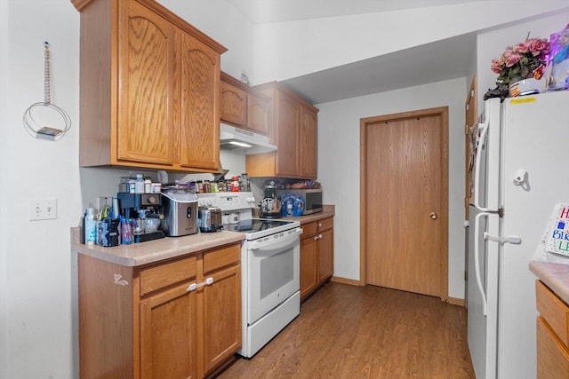 kitchen with white appliances and light hardwood / wood-style flooring