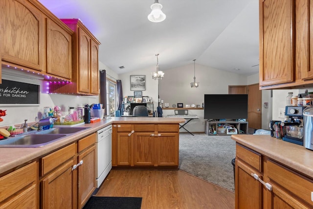 kitchen featuring vaulted ceiling, sink, hanging light fixtures, white dishwasher, and light wood-type flooring