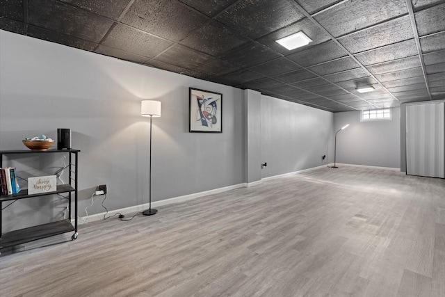 basement with hardwood / wood-style flooring and a paneled ceiling