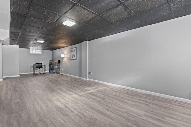 basement featuring a paneled ceiling and wood-type flooring