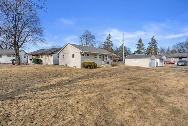 view of front of home with a garage, an outdoor structure, and a front yard