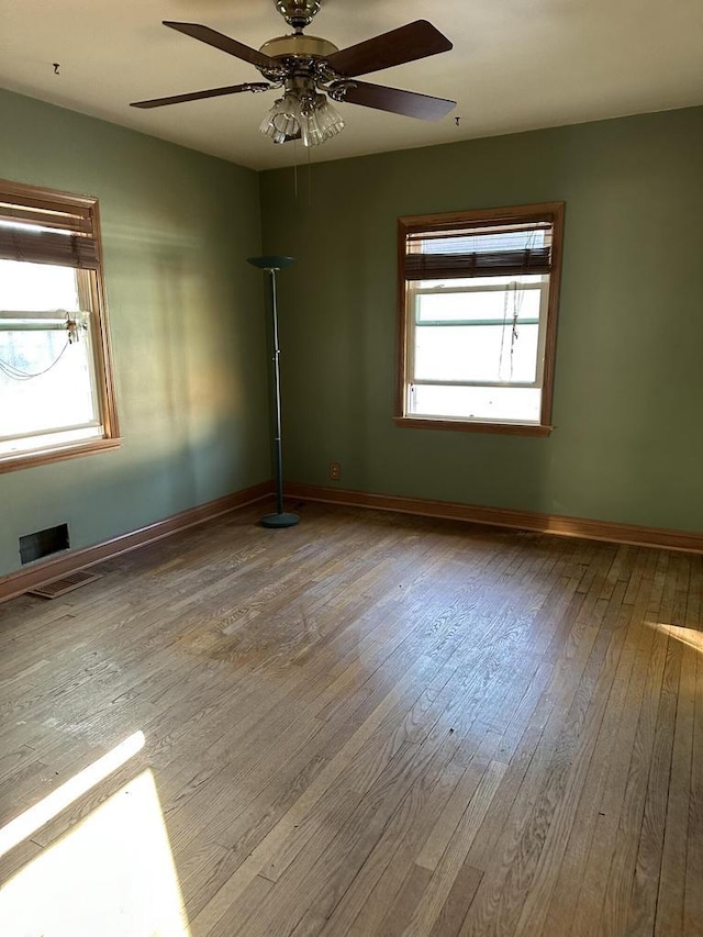 unfurnished room with a wealth of natural light, ceiling fan, and light wood-type flooring