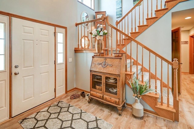 foyer with light hardwood / wood-style floors and a high ceiling