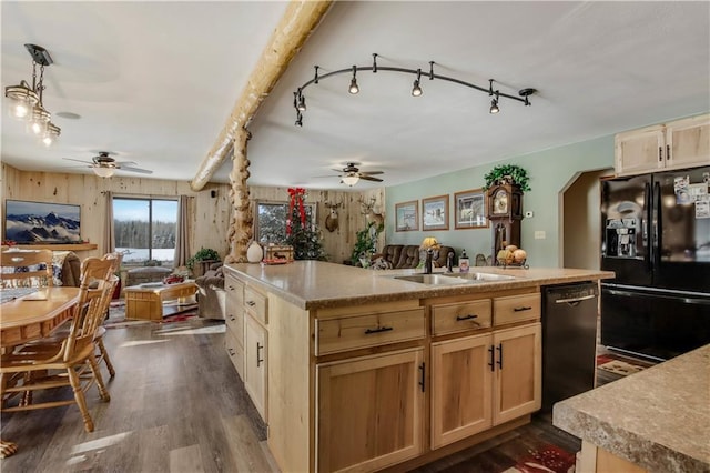 kitchen with light brown cabinetry, sink, black appliances, and a center island with sink