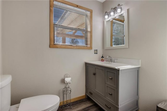 bathroom with wood-type flooring, vanity, and toilet