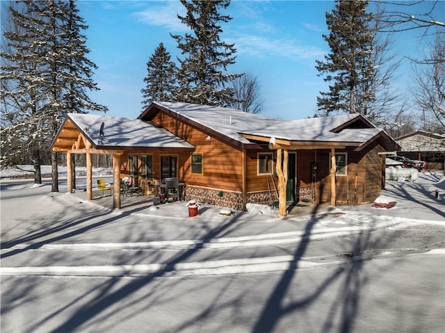 snow covered property with covered porch