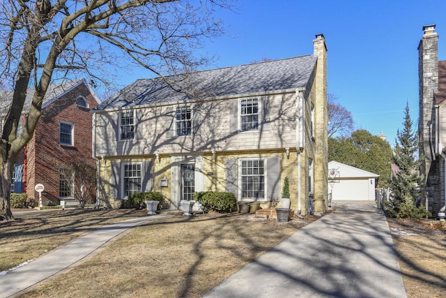 colonial house featuring a garage and an outdoor structure