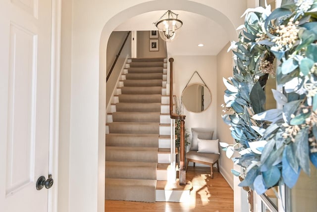 staircase featuring a chandelier and hardwood / wood-style floors