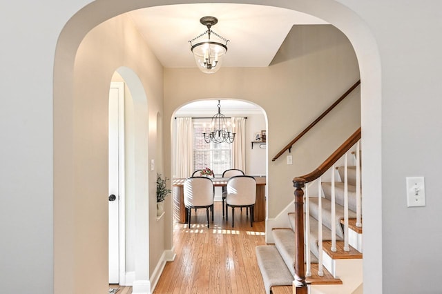 entrance foyer featuring wood-type flooring and an inviting chandelier