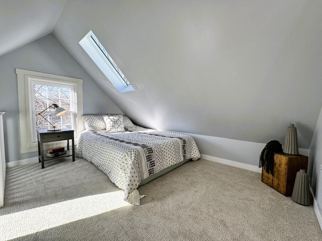 carpeted bedroom featuring vaulted ceiling with skylight