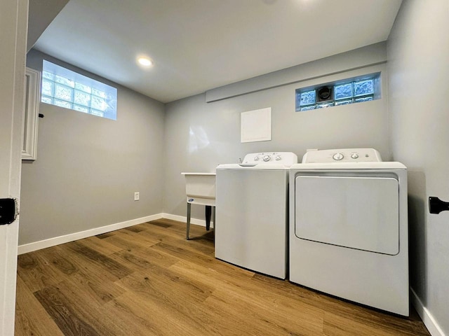 laundry area featuring independent washer and dryer and light hardwood / wood-style flooring