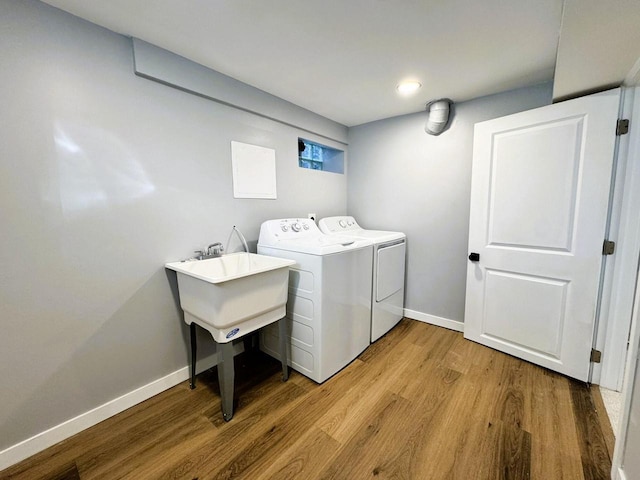 laundry room featuring sink, hardwood / wood-style floors, and washer and clothes dryer